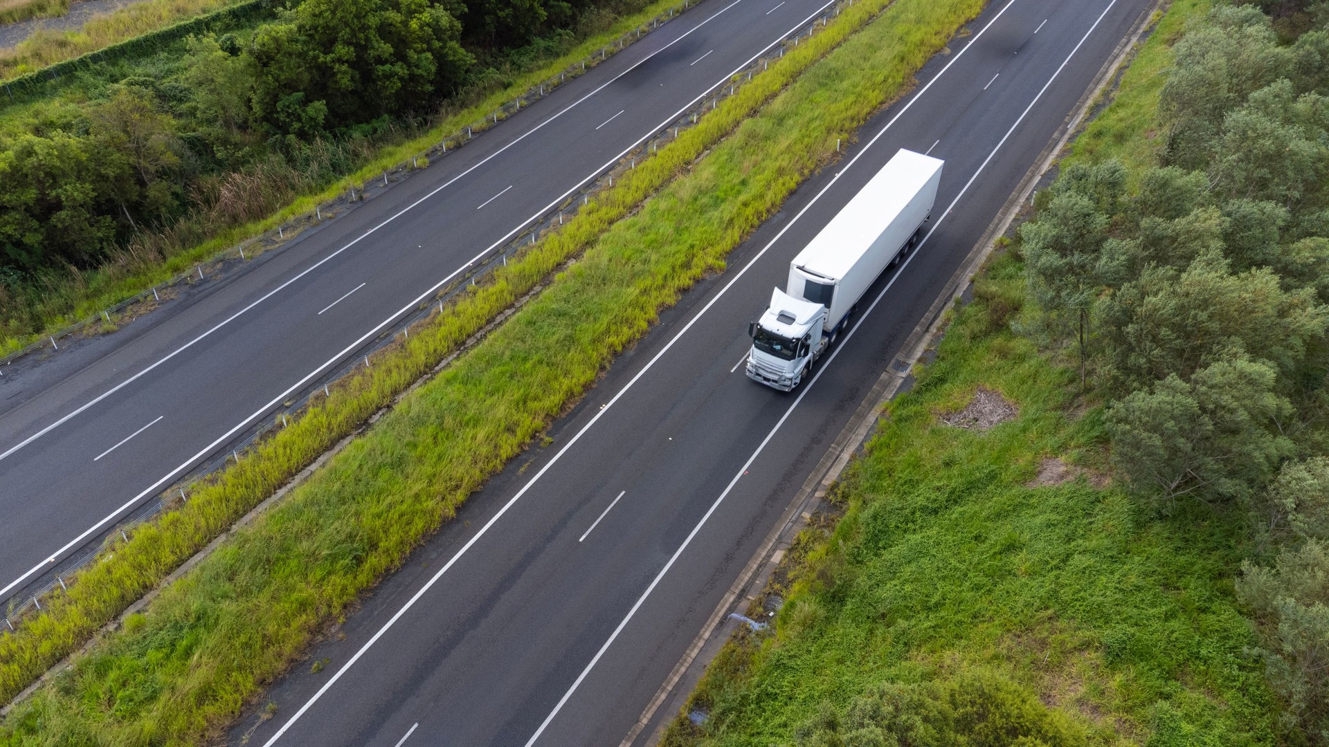 Semi trailer truck driving through lush countryside