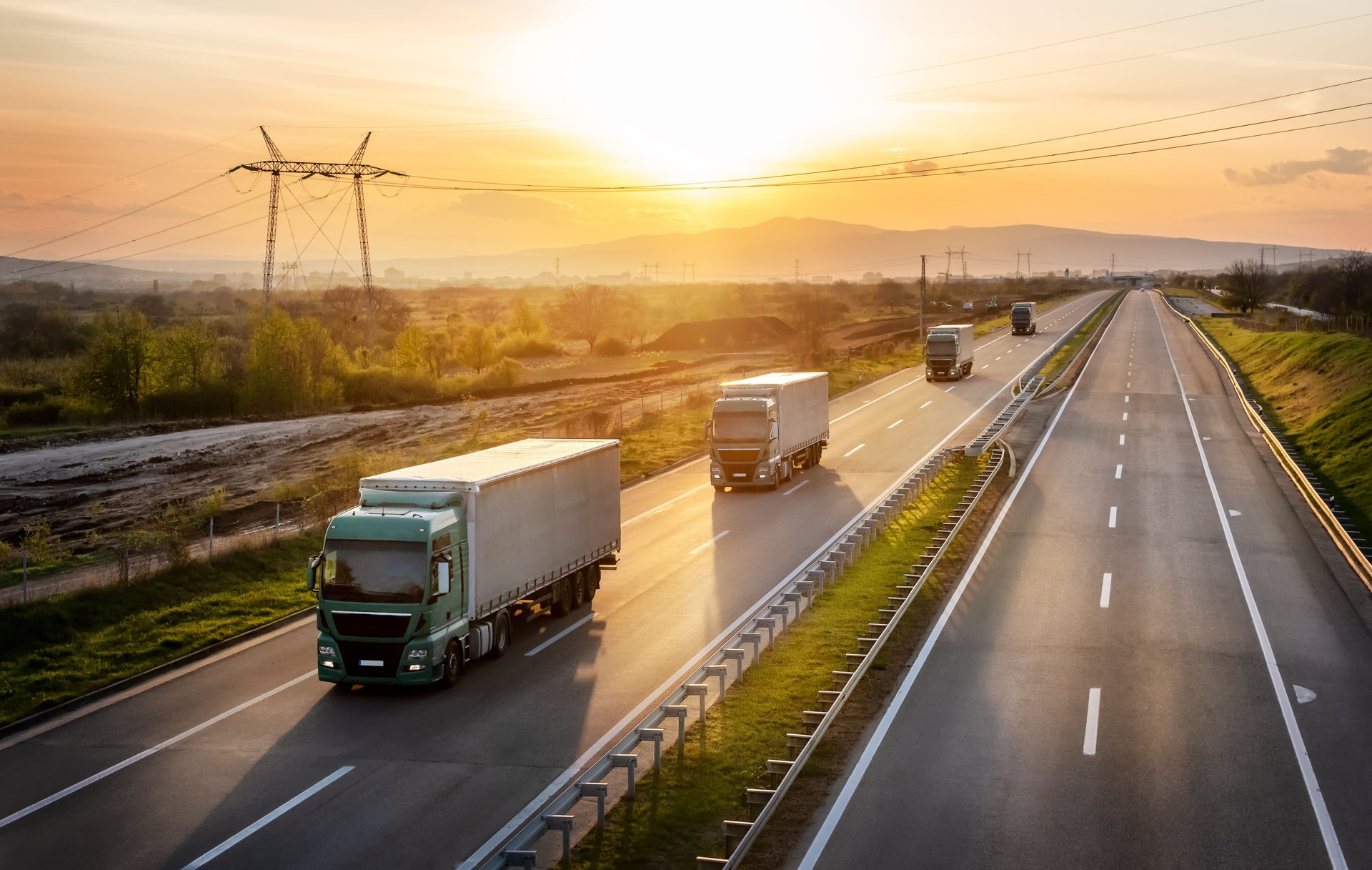 Convoy of four green trucks along the highway